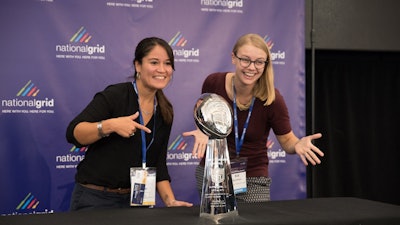 Summit attendees posing with Lombardi Trophy