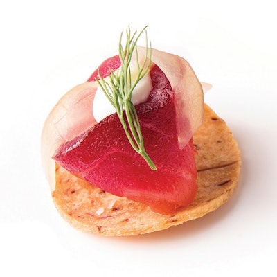 Beet cured salmon with champagne pickled cucumber and creme fraîche on taro root chip