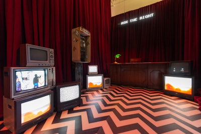The check-in area was inspired by David Lynch—specifically the red room from Twin Peaks—and featured glitchy televisions and ringing pay phones that gave guests cryptic information about the event.