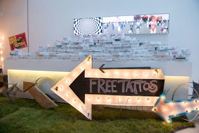 A marquee sign directed guests to get free tattoos. The room also had stacked boxes of Krispy Kreme doughnuts, one of the event's sponsors.