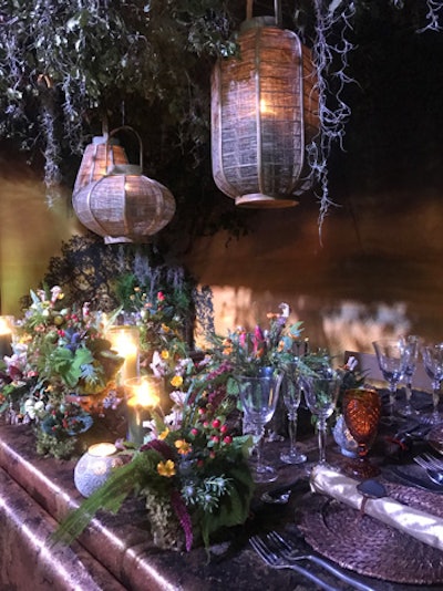 Hogue & Co also designed lush florals for the woodland area of the gala. Hanging branches, lanterns and candles, and deep brown tablecloths added to the woodsy vibe.