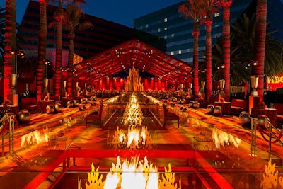 At another Billy Butchkavitz-designed HBO Emmys party, held in Los Angeles in 2015, real fire was a decorative element: 24-foot-long reflecting ponds showcased multiple flaming sculptures. A 27-foot-high flame sculpture on a rotating platform was the party’s centerpiece, and ombré-patterned custom carpet covered 50,000 square feet underfoot. The event's 25-foot-high decorative perimeter walls were covered with flowing draperies embellished with iridescent paillette sequins and punctuated by 25-foot-high red lacquer columns.
