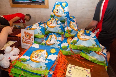 Families ended up creating over 100 stuffed animal kits designed to lift the spirits of local children in need; each kit included a hand-stuffed animal with a custom-designed T-shirt, a handwritten note, and a birth certificate that kids could fill out.