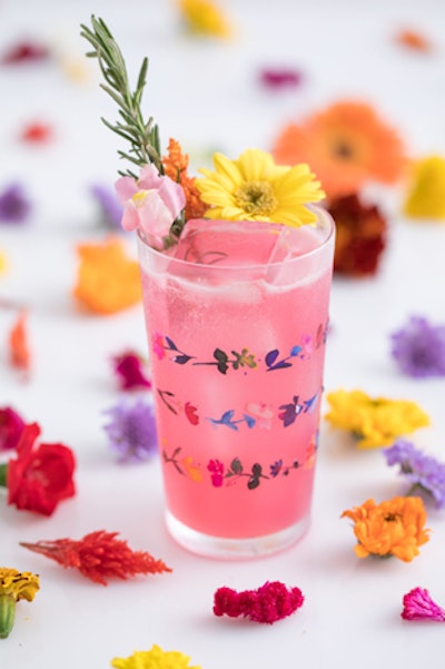 Cocktail made from tequila infused with fresh hibiscus and chamomile flowers, lime, and orange blossom honey, garnished with hibiscus and chamomile flowers, by Cocktail Academy in Los Angeles.
