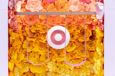 Target Beauty used swings in its booth, which the brand tapped MKG to design. Oversize paper flowers in shades of orange, yellow, and red filled the area.