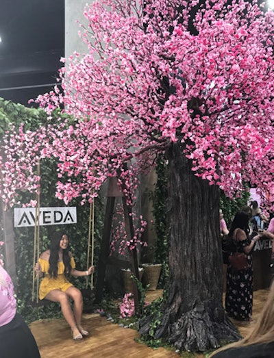 Aveda promoted its new Cherry Almond shampoo and conditioner with an eye-catching booth featuring a cherry blossom tree. Guests could pose on a swing underneath the tree.