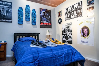 A bedroom set had posters for Dr. Dre, Beastie Boys, and others 1990s favorites on the walls. Products from the new shoe line were displayed on the bed.