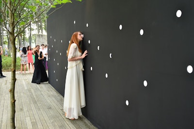 Baboo Liao, Adrian Damian, and Mariano Marquez's 'Domestic Science' was erected atop a long wooden stage and was carved with dozens of peepholes to allow guests to view the seemingly mundane goings-on inside the all-black structure.