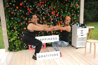 In the Beauty Garden, attendees are invited to pose with signs in front of a floral wall with Sicilian blood oranges, highlighting a key ingredient in Swisse's Hair Skin Nails Liquid Ultiboost product.
