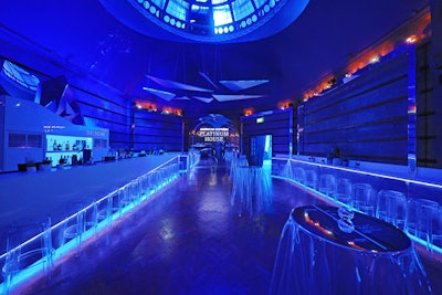 The section with the main bar was lit in blue and featured transparent seats and table coverings. A reflective arch also displayed the American Express Platinum House logo.