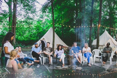 Attendees gathered around a campfire for an intimate evening of intention-setting, live music, performances, and s'mores.