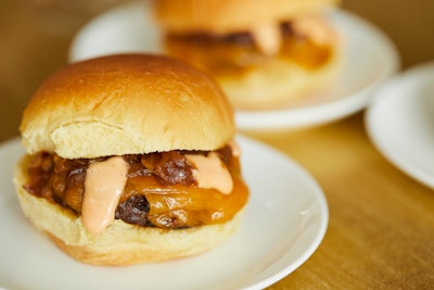 Angus beef sliders with aged cheddar, caramelized onions, and tomato aioli on a potato roll