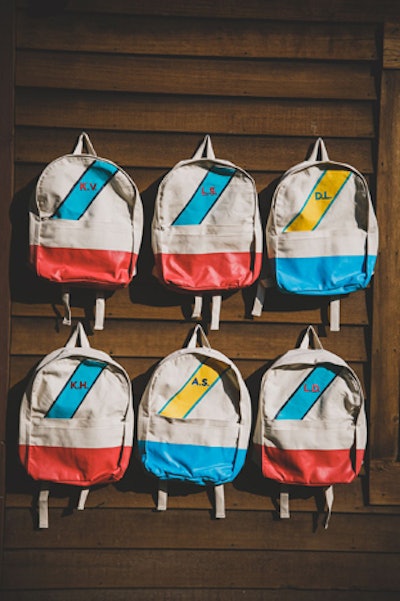 Hand-painted backpacks with the attendee’s initials hung from the facade of a small lodge.