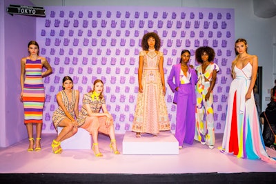 For the Tokyo setting, models wearing graphic prints and bold stripes posed in front of a wall lined with purple lucky cat figurines.