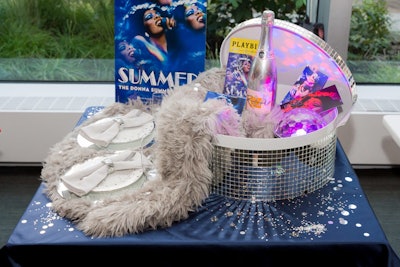 BKSK Interiors designed a disco-theme basket inspired by Summer: The Donna Summer Musical. The display featured a poster and signed playbill, two Riedel stemless champagne flutes, a 48-inch diameter faux sheepskin rug, and two tickets to see the musical and go on a backstage tour.