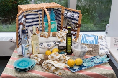 Inspired by Mamma Mia!, McCory Interiors designed an Aegean teal-hued basket that highlighted the brand’s woven coverings, cushions, and napkins. Additional items included a picnic basket with a cooler in Duralee fabric, bottles of Ouzo and Moschofilero Boutari wine, a jar of olive tapenade, a marble mortar and pestle, and a CD of the cast recording.
