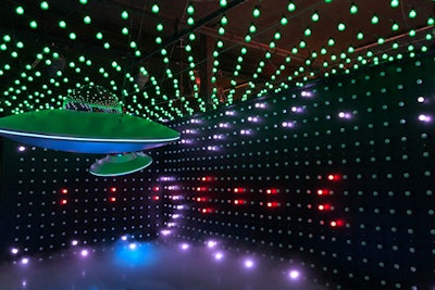 Pulsating rows of lights strung horizontally along the walls and dangling U.F.O.s create the effect of a space invasion.