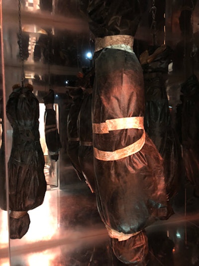 Hidden behind the washing machines is a secret room filled with dangling body bags.
