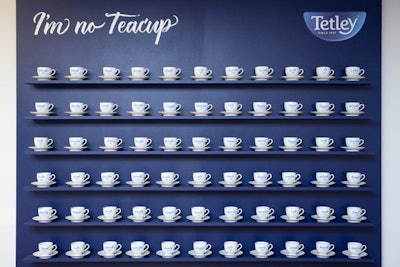 A wall displayed white teacups inscribed with blue words such as 'weak,' 'timid,' 'delicate,' and 'fragile.' The cups were examples of what attendees could smash.