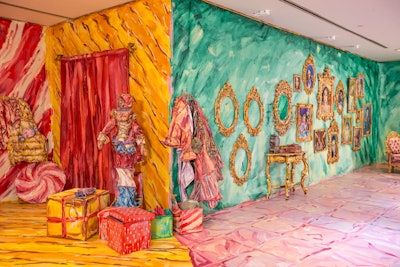 The 3,000-square-foot exhibit features three-dimensional painted holiday vignettes that create the illusion of a two-dimensional painting when photographed. Each of the seven spaces offers a different theme, such as a festive red playroom or a portrait-filled foyer.