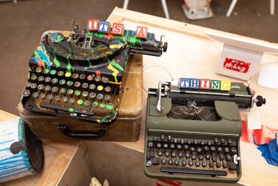 Paint-splattered, vintage typewriters incorporated the name of the organization in wooden alphabet blocks.