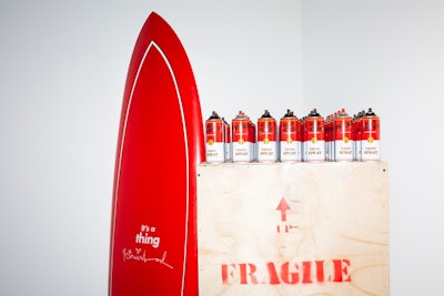 The organization's name also was displayed on a red surfboard, placed next to Andy Warhol-inspired graffiti 'tomato spray' paint cans.
