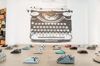 One room showcases rows of vintage typewriters, which spool pages with words and phrases typed by attendees. Each piece of artwork created by Mr. Brainwash is intended to celebrate body functions made possible by the head and neck.