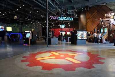 Housed in a 30-year-old warehouse in Los Angeles, Two Bit Circus's decor is designed to be imperfect and nostalgia-inspiring, with irregular detailing, mismatched wood textures, and simple string lights. A main draw for the public is the arcade area, which has 27 different games. While many of them resemble typical arcade games, most are infused with updated technology that allows the content to be switched out as needed. Many of the games also require some level of physical exertion, such as the Twister-inspired Button Wall, which gets the heart rate going and encourages interaction.
