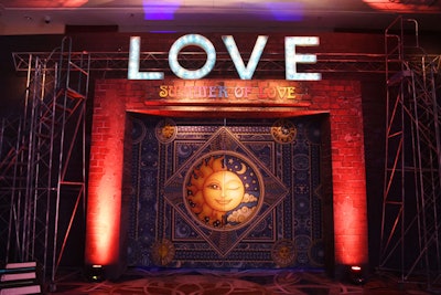 An astrology-theme doorway displayed a gold sun and moon against a blue backdrop, based on a children’s day parade Blandford attended. The word 'love' was placed above the door in marquee letters.