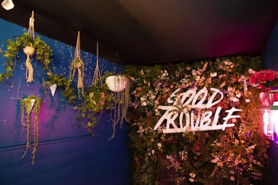 In one truck, mismatched chairs, deep blue walls, framed pictures, and hanging plants created a cozy but trendy atmosphere. A floral wall at the back doubled as a photo backdrop.