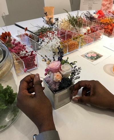 Carefully arranging flowers in a Petal+Eon bouquet