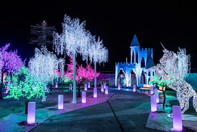 A whimsical forest includes trees with lights in a variety of colors, an illuminated unicorn, and a winter castle that seems straight out of Frozen.