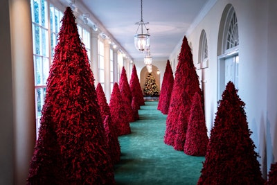 The White House holiday decorations feature a hallway of 45 red Christmas trees, created with Styrofoam and cranberries.