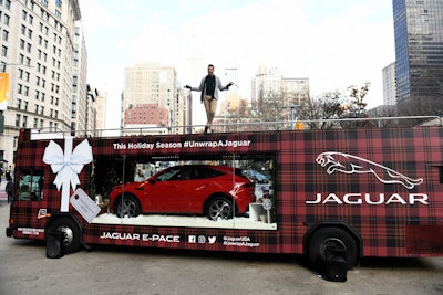 On December 11, Jaguar and HGTV personality Jonathan Scott unveiled the automaker's national 'Unwrap a Jaguar' campaign at Flatiron Plaza South in a manner that, according to Taylor Hoel, manager of media strategy and planning at Jaguar Land Rover, was anything but a traditional paid media campaign. The design guru transformed a bus into a mobile looking glass, complete with vinyl tartan wrap, a gift tag, and a snowy wintery landscape, to display Jaguar's compact performance E-Pace SUV.