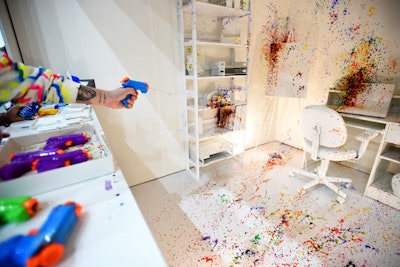 In one installation, guests shot water guns full of paint at a white office setting.
