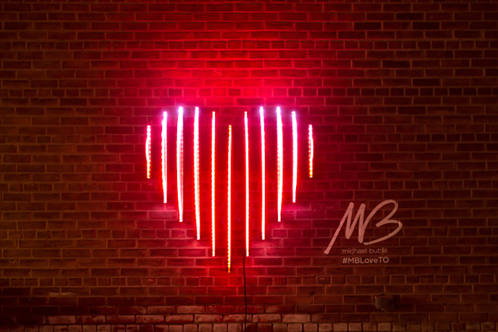 Michael Bublé’s Edge Lit Heart is a kinetic light sculpture inspired by Canadian singer's album Love (stylized as the red heart emoji). The sculpture incorporates hundreds of animated LEDs to light eleven acrylic panels. Toronto-based visual artist Craig Small created the sculpture.