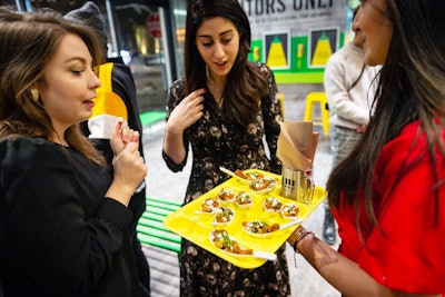 At the pop-up's opening night party, small bites were served on yellow, cafeteria-style trays.