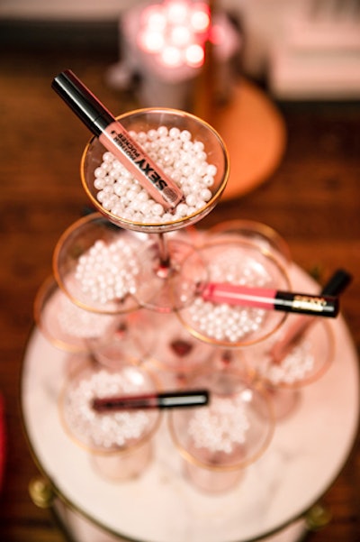Champagne glasses filled with pearls served as product display stands.