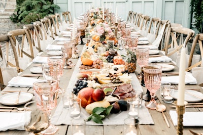 Instead of a standard table runner, Contemporary Catering provided 24 feet of hand-selected cheese, charcuterie, seasonal fruits, and vegetables. Borrowed Blu handled tabletop rentals.
