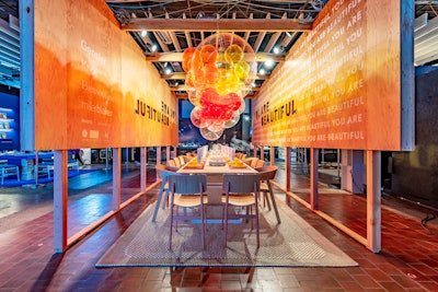 The vignette by Gensler, Knoll, and EvensonBest, titled “You Are Beautiful,” was designed as a reminder to those living with HIV/AIDS that they are beautiful and not alone in their fight. Flanked by wooden cut-out panels with block lettering, the table-long ceiling installation was comprised of translucent and clear beach balls.