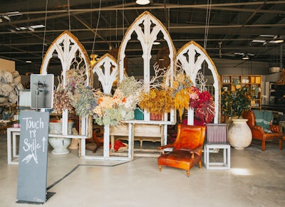 A photo vignette invited guests to pose with florals, vintage furniture, and Gothic window frames.