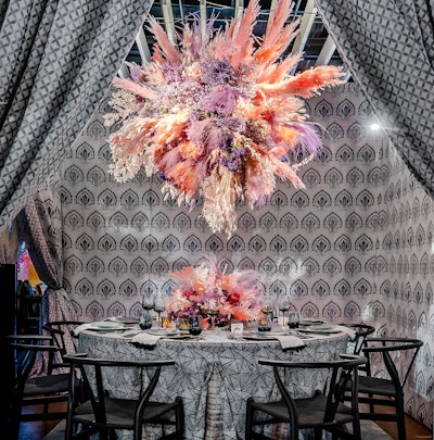 Designed by Stacy Garcia, in collaboration with Crypton Home Fabric and Calico, this setting featured soft gray tones representing winter and an explosion of pinks, purples, and pastel colors of spring in the ceiling installation and table centerpiece. Floral design was provided by L’Olivier Floral Atelier.