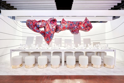 Designed by Stonehill Taylor for Japanese textile company Ultrafabrics, “Journey” refers to nearly four decades of research in the fight against AIDS. The large, amorphous ceiling installation featured colors and patterns evocative of the body against a stark white dining table and vegan leather-backed seating.