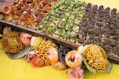 The floral theme continued to the food table, where small bites from La Saison rested atop pink, yellow, and orange flowers.