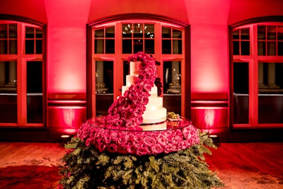 Bold Catering & Design in Atlanta created a massive cake centerpiece for a holiday-theme reception. Led by designer Brian Worley, the design team took a full-size tree and cut it to 40 inches, creating a 'skirt' with the branches. They then built a custom table and glass topper for the five-tier cake and an arrangement of 500 red roses that cascaded from the top of the cake to the base.