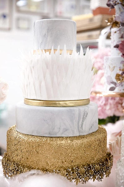 NY Cake also offers Feather Magic, a cake with lemon chiffon and alternating layers of lemon curd and vanilla Swiss buttercream. The cake has tiers of marbled fondant, edible rice paper, and sugar sequins.