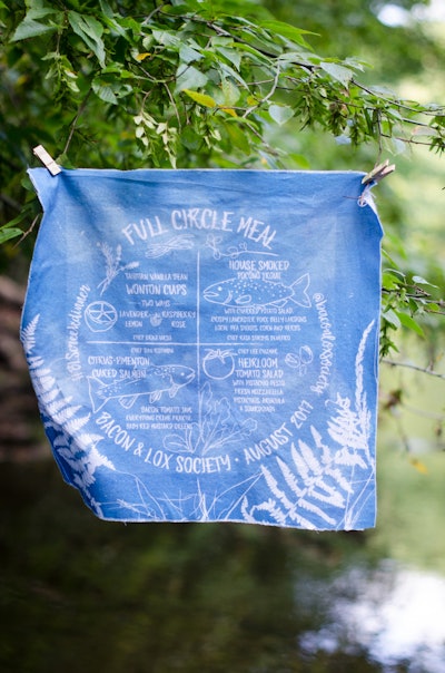 At the Bacon & Lox Society’s Full Circle Meal event in August 2017, blue cyanotype prints were incorporated onto the napkin menus, which were created by Gifts for the Good Life. See more: How Some Planners Are Using Events to Bring Divided Communities Together