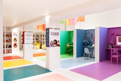 The space features vintage beauty salon booths in different colors that extend to the floor. Columns are wrapped with imagery about the fund-raising campaign.