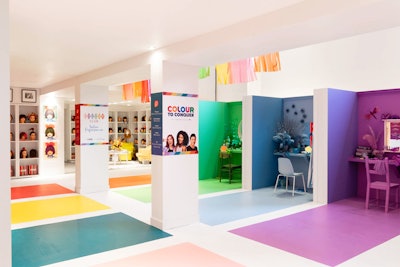The space features vintage beauty salon booths in different colors that extend to the floor. Columns are wrapped with imagery about the fund-raising campaign.