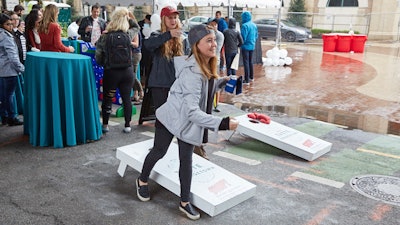 Attendees at the Taste of Georgetown enjoy playing a couple of custom branded cornhole games.